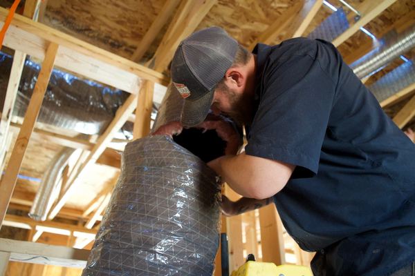 Five Star Mechanical tech connecting flex duct to a register box in the attic