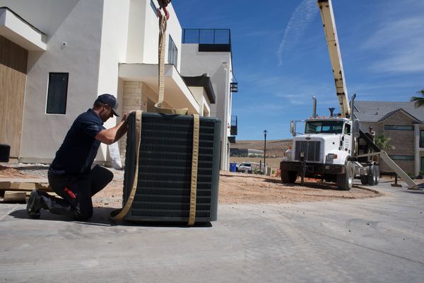 Five Star Mechanical tech rigging a new condenser before crane lift to rooftop