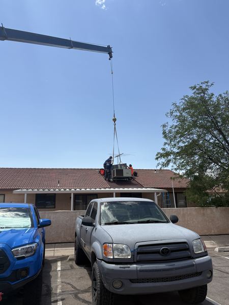 Five Star Mechanical roof crew preparing to land a new AC unit with crane assist