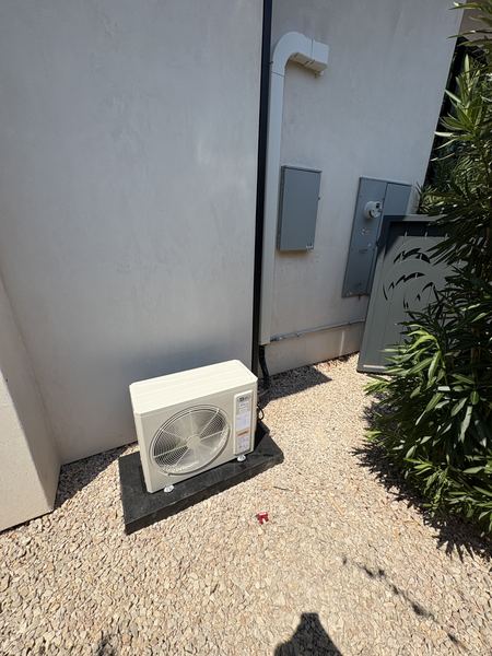 Mini-split outdoor unit cleanly installed against a stucco wall