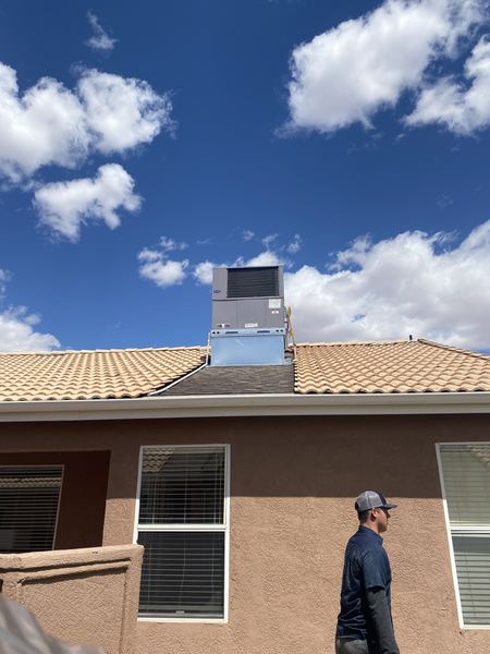 Five Star Mechanical tech walking past a freshly installed Carrier rooftop package unit