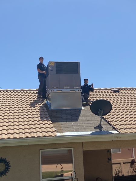 Two Five Star Mechanical techs on a tile roof after a Carrier package unit install
